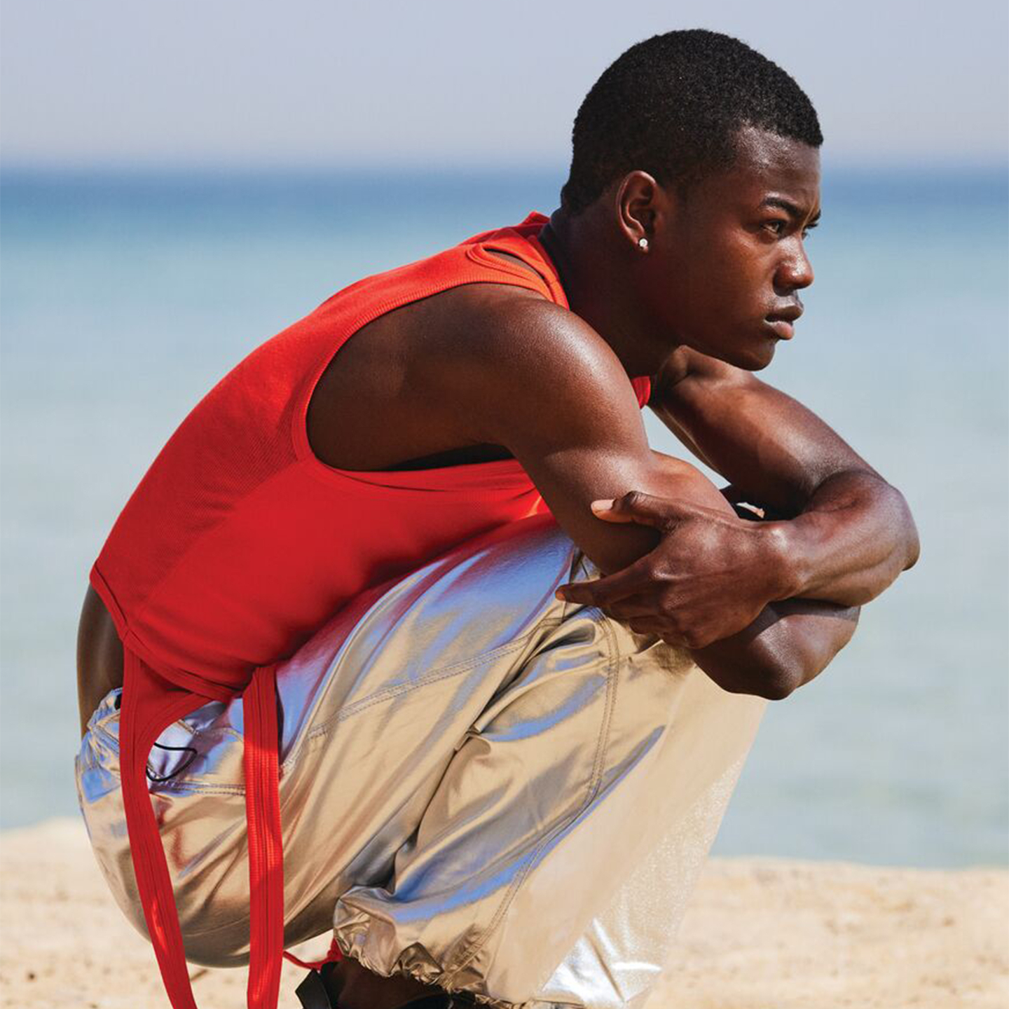 Contemplative man sitting on the beach, symbolizing relaxation and self-care.
